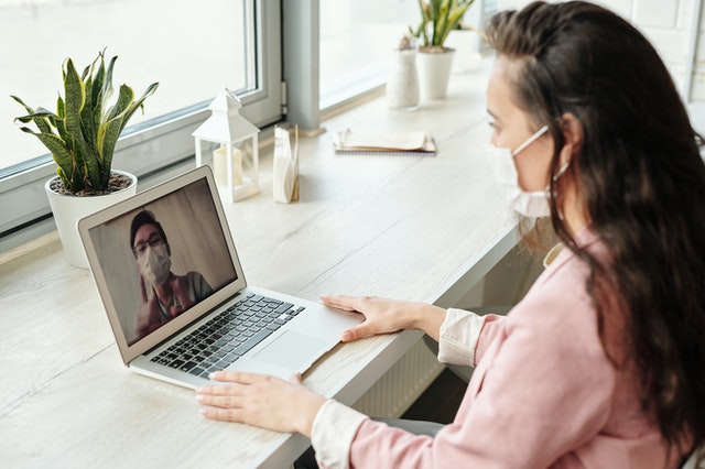 Woman interacting with man on laptop