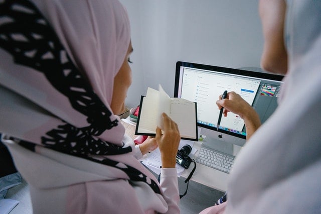 woman in hijab in front of imac
