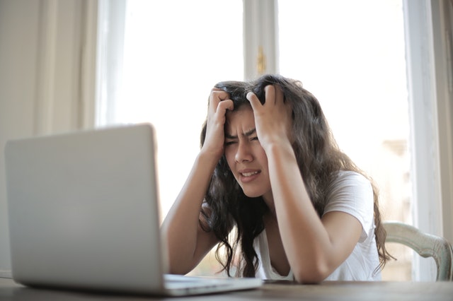 Woman showing frustration in front of laptop